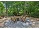 Relaxing backyard fire pit area with Adirondack chairs surrounded by lush greenery, perfect for entertaining friends at 750 Crest Valley Nw Dr, Sandy Springs, GA 30327