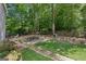 Private backyard retreat with stone patio, dining set, and mature trees create a tranquil oasis at 750 Crest Valley Nw Dr, Sandy Springs, GA 30327