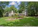 Spacious backyard with large lawn, stone patio, and mature trees offer a private outdoor retreat at 750 Crest Valley Nw Dr, Sandy Springs, GA 30327