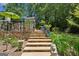Landscaped backyard featuring a stone patio, dining set and lush greenery at 750 Crest Valley Nw Dr, Sandy Springs, GA 30327