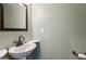 A pedestal sink and framed mirror in a well-lit bathroom at 750 Crest Valley Nw Dr, Sandy Springs, GA 30327