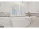 Bright bathroom with a standalone tub and large shuttered window at 750 Crest Valley Nw Dr, Sandy Springs, GA 30327