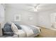 Bright staged bedroom features a ceiling fan, a plush bed, and an ensuite bathroom at 750 Crest Valley Nw Dr, Sandy Springs, GA 30327