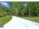 Long driveway leads to a beautifully landscaped home surrounded by mature trees and lush green lawn at 750 Crest Valley Nw Dr, Sandy Springs, GA 30327