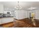 Open floor plan shows kitchen with a large island, stainless steel appliances, white cabinetry and view into another room at 750 Crest Valley Nw Dr, Sandy Springs, GA 30327