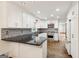 Well lit kitchen features stainless steel appliances, granite counter tops, tiled backsplash, and white cabinets with modern hardware at 750 Crest Valley Nw Dr, Sandy Springs, GA 30327