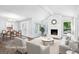 Bright, virtually staged living room with stone fireplace, large windows, and adjacent dining area at 750 Crest Valley Nw Dr, Sandy Springs, GA 30327