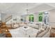 Bright, staged living room with white furniture, large windows, hardwood floors, and a neutral color palette at 750 Crest Valley Nw Dr, Sandy Springs, GA 30327