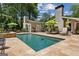 The backyard boasts a sparkling pool, spa, stone patio with lounge furniture, and umbrellas for luxurious outdoor living at 750 Crest Valley Nw Dr, Sandy Springs, GA 30327