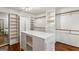 Large walk-in closet with custom shelving, drawers, and center island at 750 Crest Valley Nw Dr, Sandy Springs, GA 30327