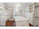Spacious walk-in closet with custom shelving, drawers, and hardwood floors at 750 Crest Valley Nw Dr, Sandy Springs, GA 30327