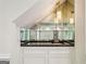 A mirrored wet bar beneath a staircase and countertop at 750 Crest Valley Nw Dr, Sandy Springs, GA 30327