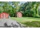 View of two storage sheds with red paint situated on a spacious and well-maintained lawn area at 4236 Florida Nw Ave, Atlanta, GA 30360