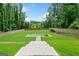 Backyard featuring a modern pool design, surrounded by green lawn and mature trees for privacy at 103 Maddox Rd, Buford, GA 30518