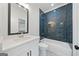 Modern bathroom with blue tile accent wall, white vanity, and a shower-tub combination at 103 Maddox Rd, Buford, GA 30518