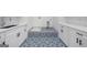 Well-lit laundry room featuring custom tile, white cabinetry, and stone countertops at 103 Maddox Rd, Buford, GA 30518