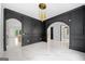 Living room area with black paneling, marble floors, and a modern gold light fixture at 103 Maddox Rd, Buford, GA 30518