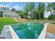 A clear view of the backyard pool with the home's exterior visible in the background, surrounded by trees at 103 Maddox Rd, Buford, GA 30518