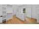 Spacious walk-in closet with hardwood floors, white shelving, drawers, and storage at 103 Maddox Rd, Buford, GA 30518