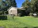Brick home with a well-maintained lawn, complemented by lush bushes and a classic chain-link fence at 90 Cabriolet Trail, Mcdonough, GA 30253