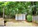 Backyard features a small storage shed, a wooden fence, and a grassy area lined with trees at 1335 Vine Cir, Mcdonough, GA 30253