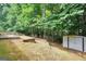 Backyard features a small storage shed, a wooden fence, and a tiered garden bed against a wooded backdrop at 1335 Vine Cir, Mcdonough, GA 30253