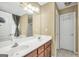 Bright bathroom with a double sink vanity, large mirror, and a separate door leading to a private toilet area at 1335 Vine Cir, Mcdonough, GA 30253