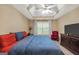 Bright bedroom featuring a tray ceiling with fan, window and red accents for a comfortable home ambiance at 1335 Vine Cir, Mcdonough, GA 30253
