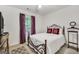 Cozy bedroom featuring an iron bed frame, carpeted floors, and a window with burgundy curtains at 1335 Vine Cir, Mcdonough, GA 30253