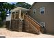 Exterior of home features staircase to upper deck, offering easy outdoor access and elevated relaxation space at 565 Scarborough Rd, Ellenwood, GA 30294