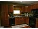 Cozy kitchen features wooden cabinets, black appliances, and a patterned rug, creating a warm and inviting atmosphere at 565 Scarborough Rd, Ellenwood, GA 30294