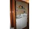 Convenient laundry room features a washer, dryer, storage shelf, and a hamper, streamlining household chores at 565 Scarborough Rd, Ellenwood, GA 30294
