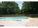 Backyard with a refreshing in-ground pool, surrounded by a concrete patio and lush greenery, perfect for relaxation at 565 Scarborough Rd, Ellenwood, GA 30294