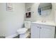 Well-lit bathroom with a white toilet, vanity, sink and a large round mirror on the wall at 24317 Plantation Ne Dr, Atlanta, GA 30324