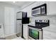 Modern kitchen featuring white cabinets, stainless steel appliances, and updated backsplash at 24317 Plantation Ne Dr, Atlanta, GA 30324