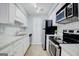Modern kitchen featuring white cabinets, stainless steel appliances, and updated backsplash at 24317 Plantation Ne Dr, Atlanta, GA 30324