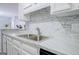 Close-up of a kitchen sink featuring a double basin, white cabinets, and a modern faucet at 24317 Plantation Ne Dr, Atlanta, GA 30324