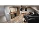 Bonus room with wet bar, dark sofa, and wooden floors with a comfortable vibe at 251 Merrell Rd, Carrollton, GA 30116