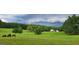 Pastoral property with a charming white house, green fields, trees, cows, and a serene, picturesque setting at 251 Merrell Rd, Carrollton, GA 30116