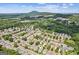 Aerial view of the community with lush trees and mountain views in the distance at 3725 Downing Dr, Cumming, GA 30040