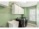 Well-organized laundry room with modern appliances, overhead cabinets, and practical sink at 3725 Downing Dr, Cumming, GA 30040