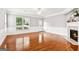 An empty living room with gleaming hardwood floors, wainscoting, fireplace, and ample natural light at 3725 Downing Dr, Cumming, GA 30040