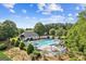 Aerial shot of the community pool with a splash fountain, lounge chairs, and shaded seating areas at 3725 Downing Dr, Cumming, GA 30040