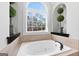 Soaking tub with a window and dark fixtures at 50 Birch Road, Covington, GA 30014