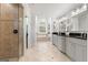 An elegant primary bathroom with dual vanities, soaking tub, large window, and glass shower at 50 Birch Road, Covington, GA 30014