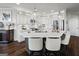 Open-concept kitchen with white cabinetry, large island, stainless appliances, and stylish pendant lighting at 50 Birch Road, Covington, GA 30014