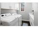 Bright laundry room features new white cabinets, countertops, and modern washer and dryer at 50 Birch Road, Covington, GA 30014