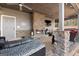 Outdoor covered porch with stone fireplace, ceiling fan, mounted television, and lounge chairs at 50 Birch Road, Covington, GA 30014