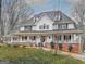 Charming two-story home with a large, welcoming wrap-around porch and mature trees at 125 Sir Lancelot Ct, Fayetteville, GA 30214