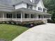 Stunning two-story home with white siding, black shutters and a welcoming wrap-around porch at 125 Sir Lancelot Ct, Fayetteville, GA 30214